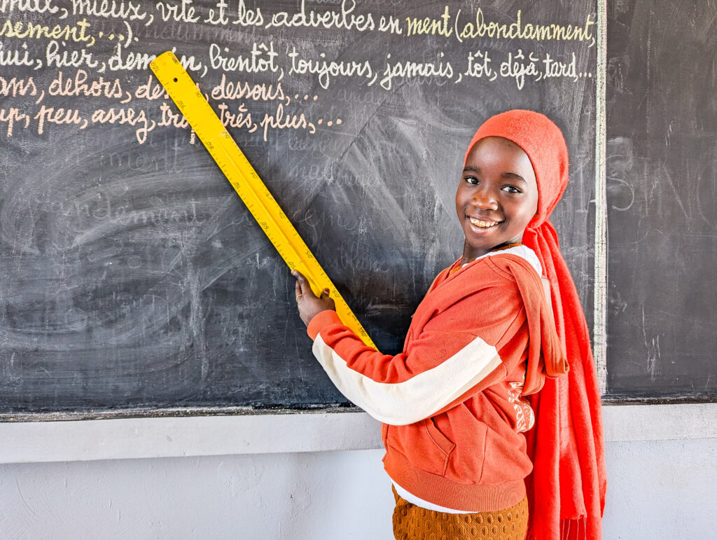 A girl in Senegal learns to read in her brand new buildOn school.