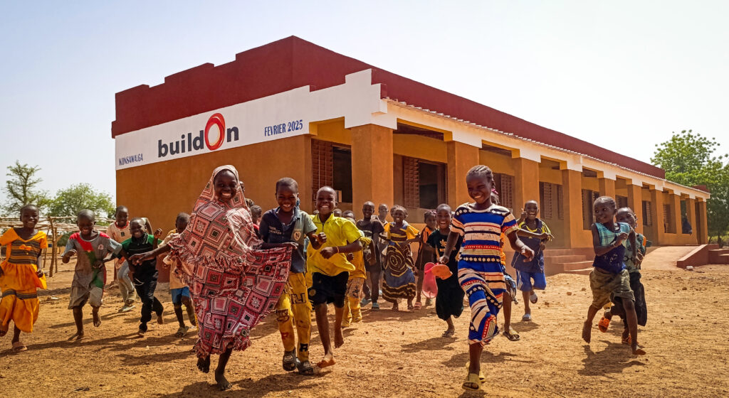 Children in Burkina Faso celebrate in front of their newly-completed school.