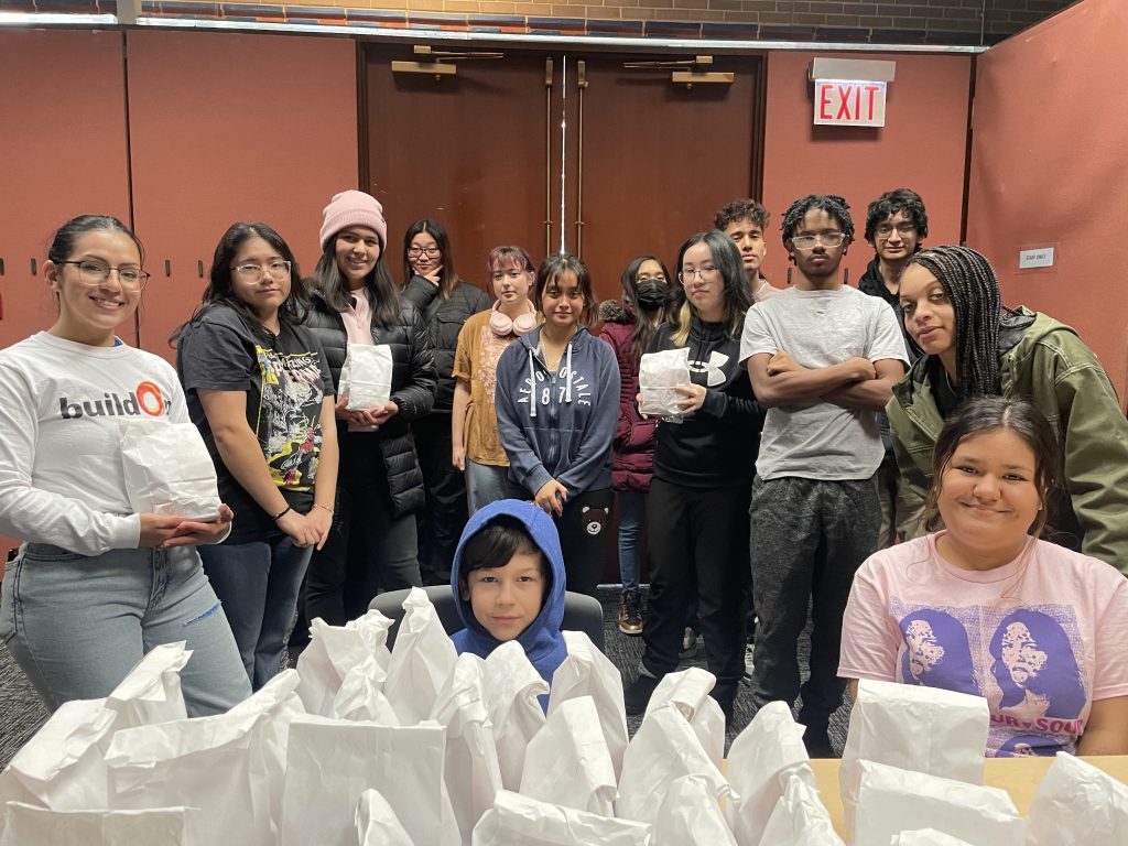 Ciara (third from left) gets ready to distribute lunch bags to Pilsen community members.