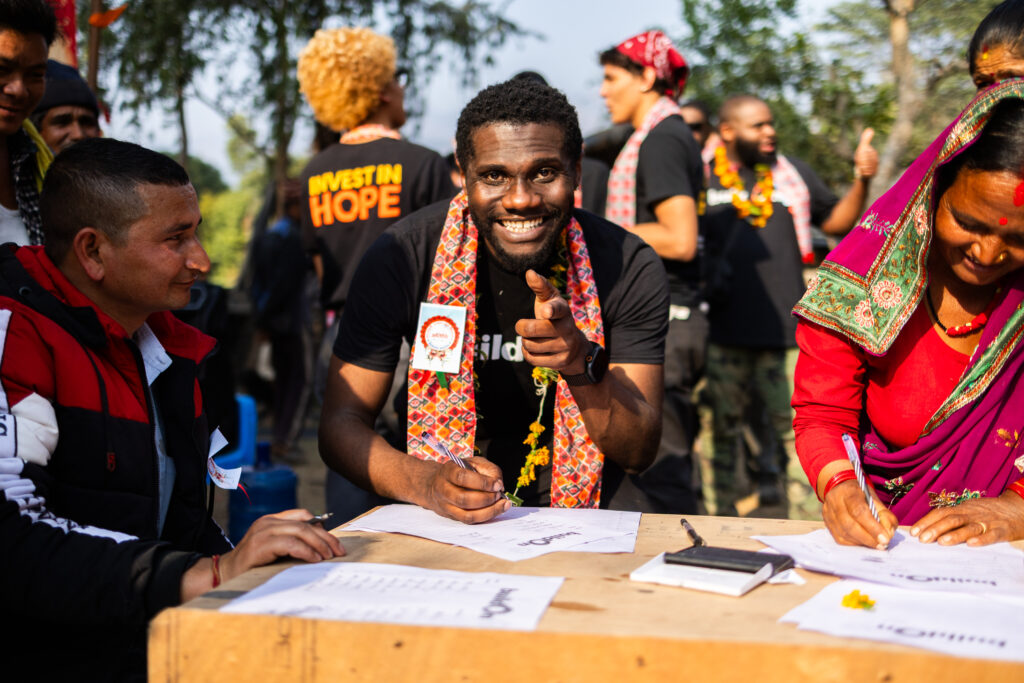 buildOn alum Dionta Brown signs a covenant with his host community on Trek in Nepal.