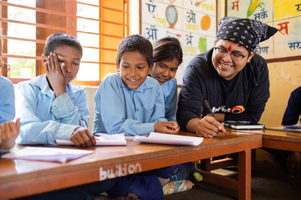 Adolfo Rodriguez helps Nepalese students in their buildOn classroom on a recent alumni Trek.