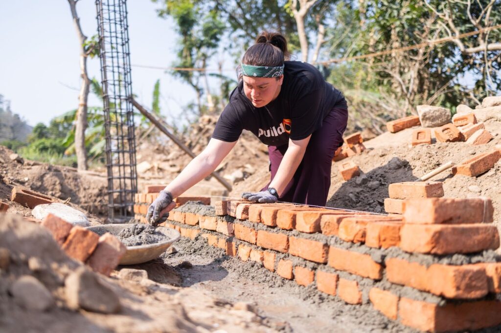 Gabriela Ojeda lays brick for a new buildOn school on her second Trek to Museti, Nepal.