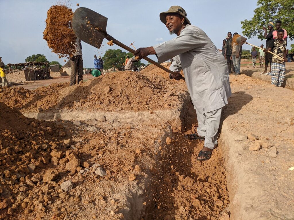 Alhousseyni Maiga, our Regional Director in Africa, shovels dirt for a school foundation in Mali.