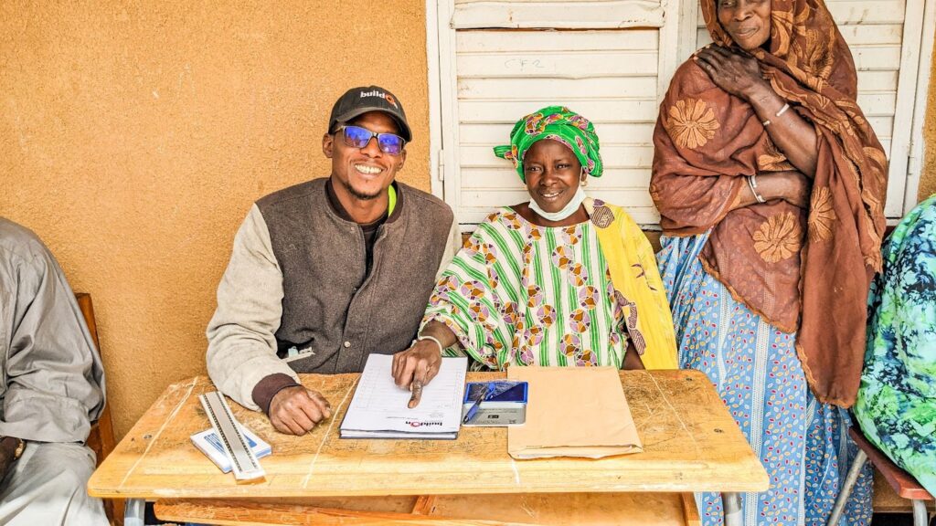 Before learning to read and write, Awa had to sign documents using her fingerprint—like in this moment, where she can be seen signing the buildOn covenant before construction began on Ndanghar’s school.