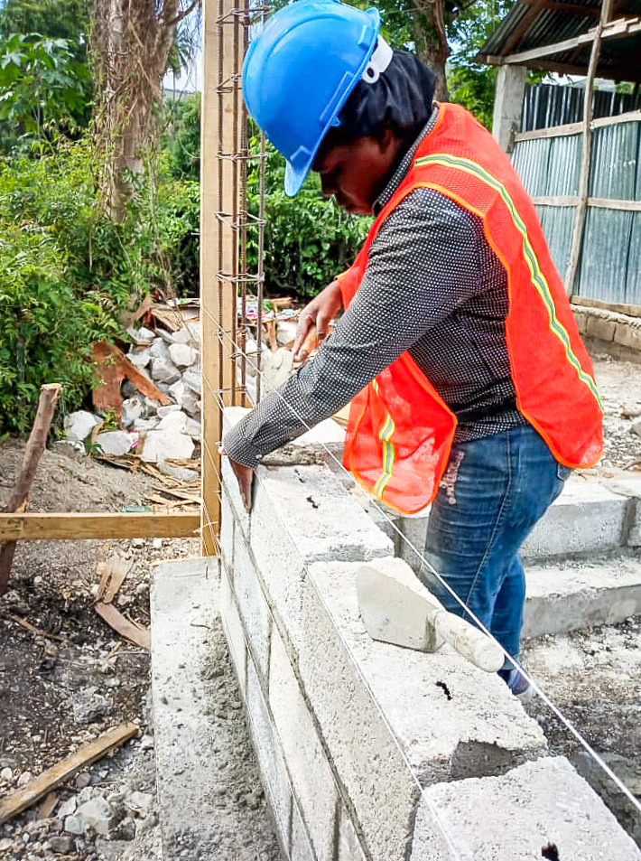 Julaine helps to lay brick, a skill she learned from buildOn’s team.