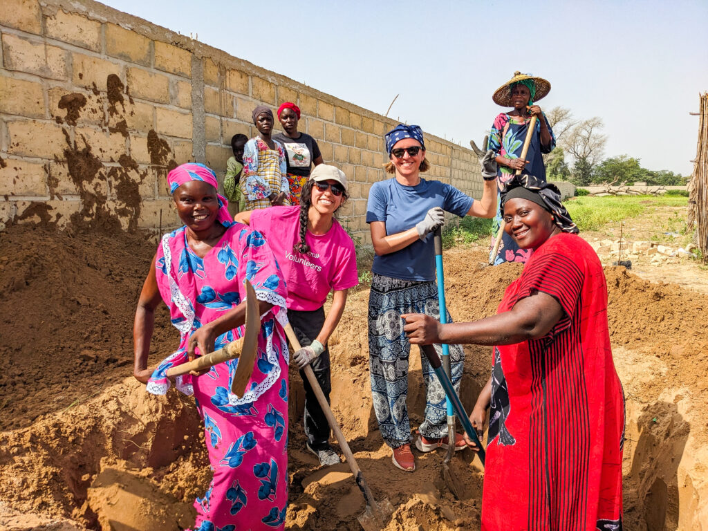 Trek participants help dig a foundation in Senegal.
