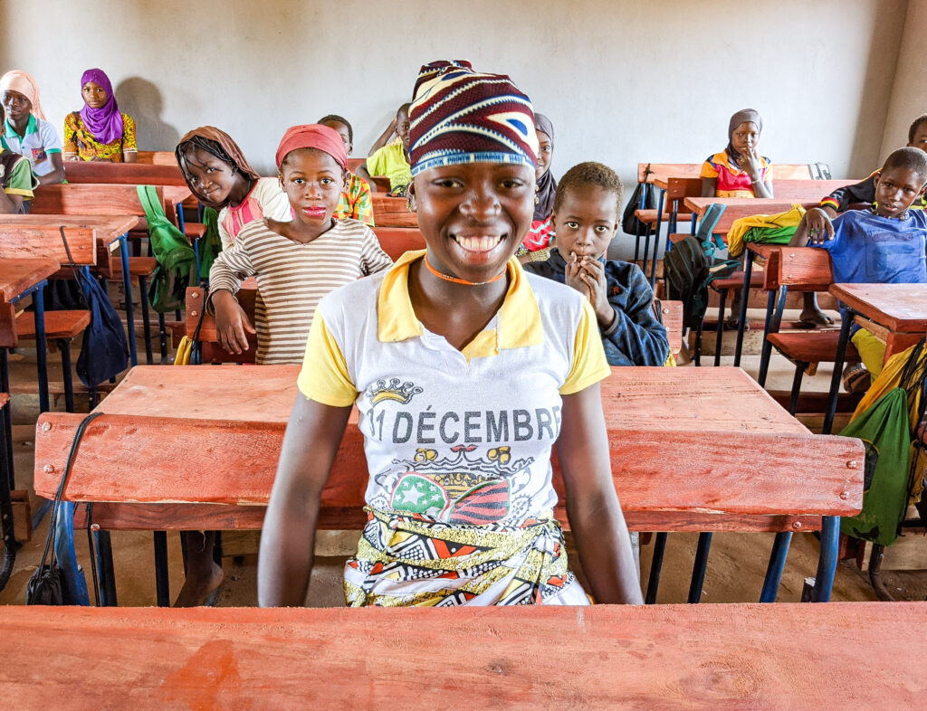 Bibatou sits with her classmates in her brand new buildOn school.