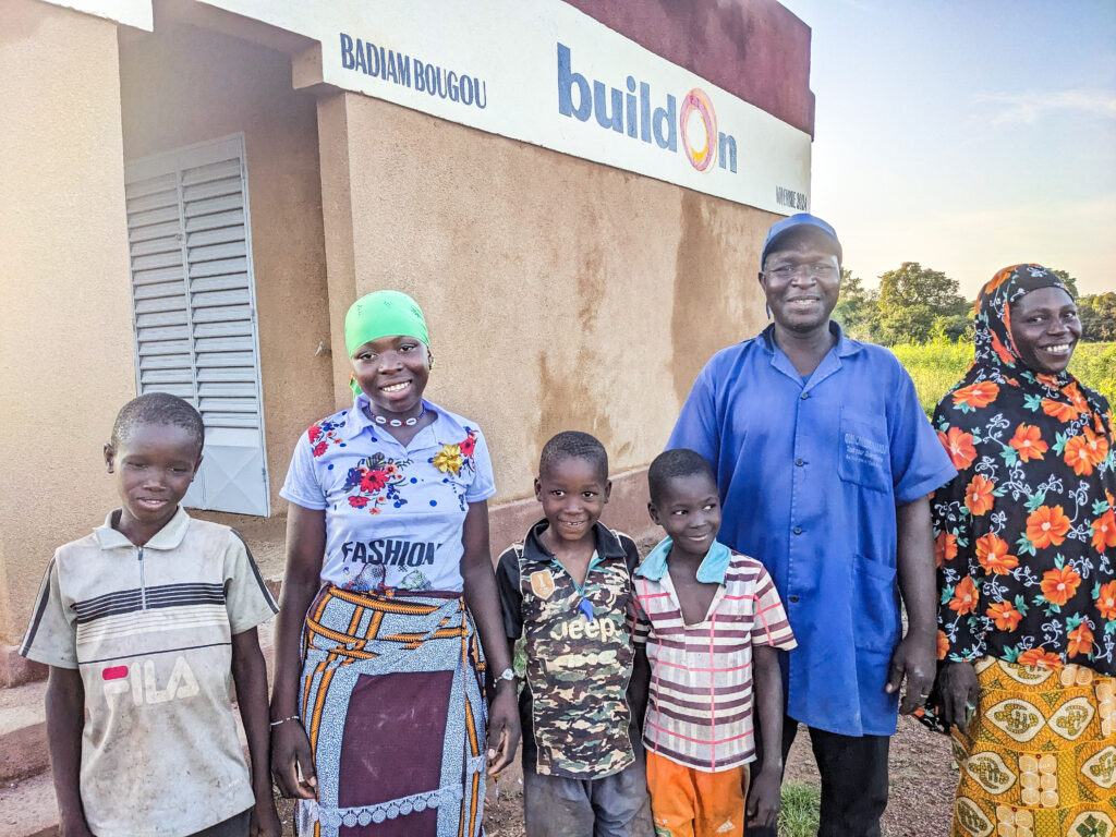 Bibatou and her family in front of her brand new school.