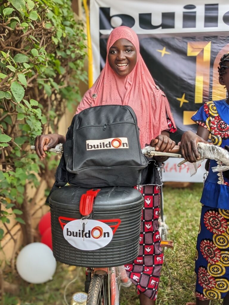 Nassiratou with the bicycle she won for earning the highest score of any student at a buildOn school in Burkina Faso on the Primary School Certificate exam.