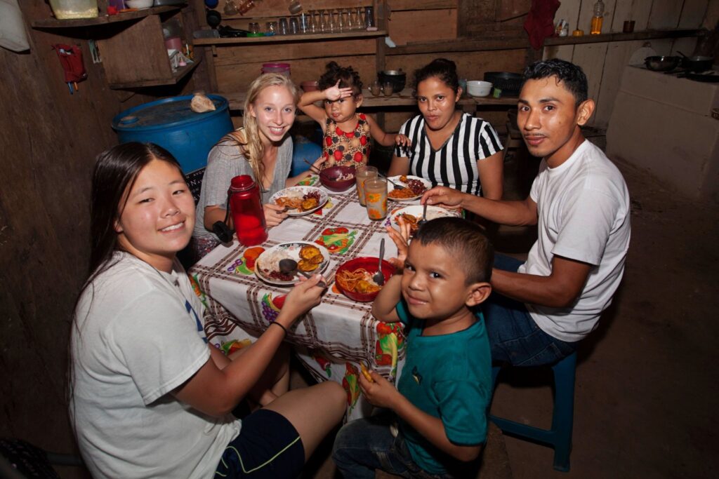 Trek participants share a meal with their host family in Nicaragua.