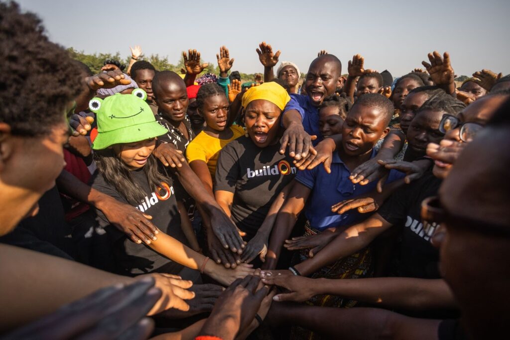 buildOn students and staff join hands with the people of Chimbwanda before starting a day’s work building our 3,000th school.