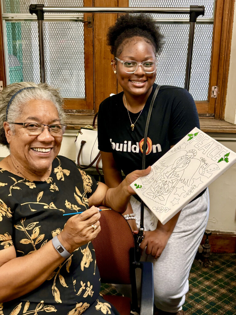 Simone paints with seniors at St. Patrick's Senior Center.