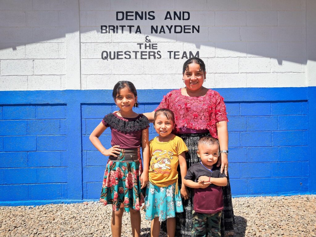 Eva Pop stands with her family. Forced to leave school as a child, she hopes her children can finish their studies.