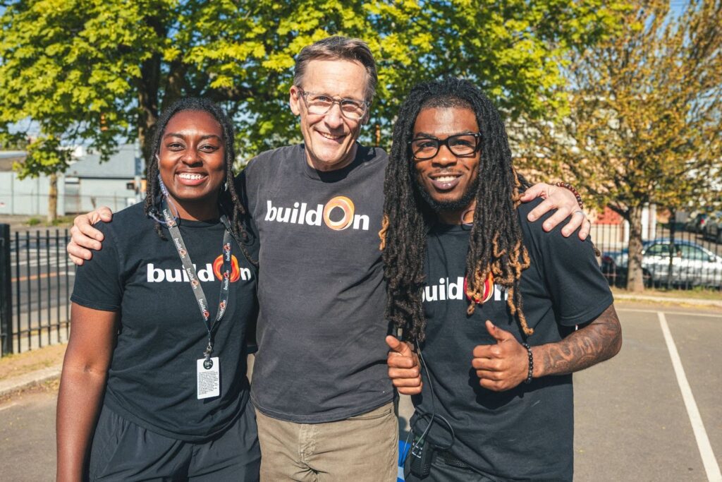 Cedric (right) stands at service alongside buildOn’s Founder and CEO Jim Ziolkowski.