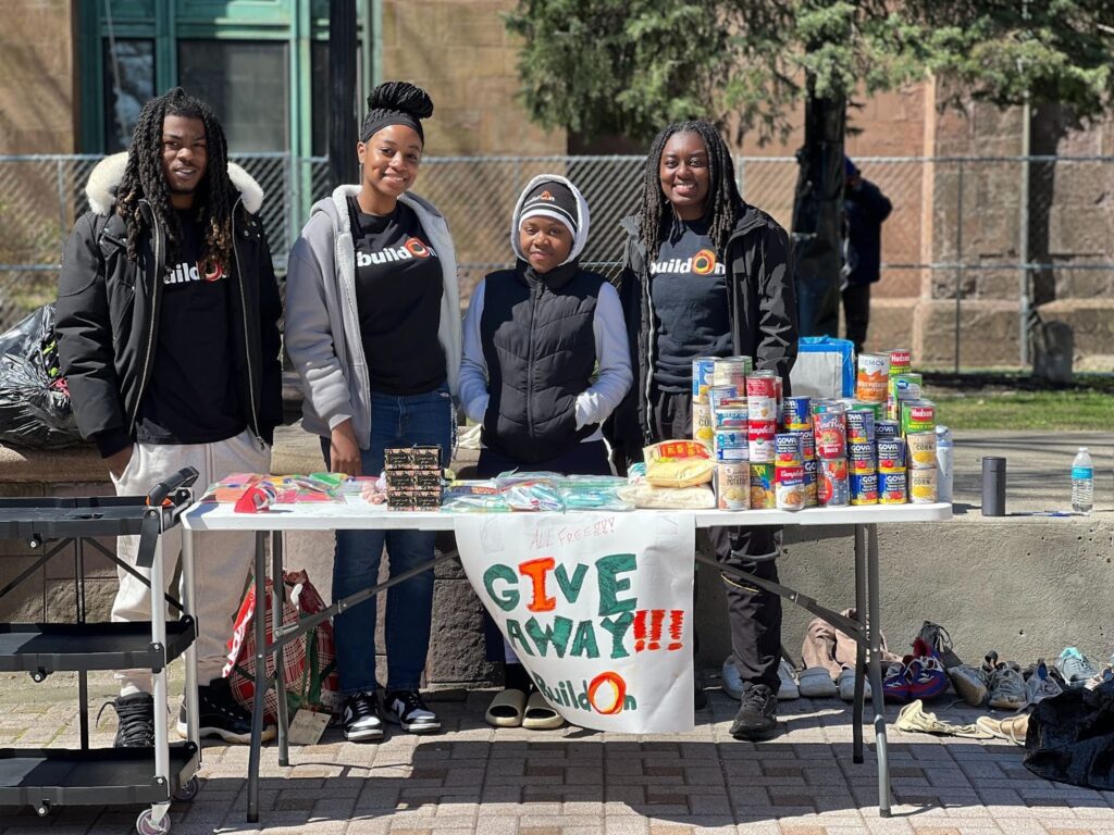 Cedric (left) serving with his buildOn students in Bridgeport and giving out food to community members in need.