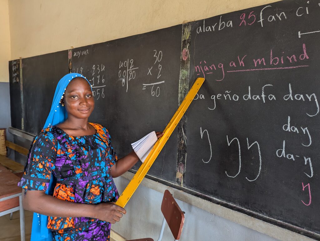 Mariama Cissé stands proudly in the classroom where she learned to read and write.