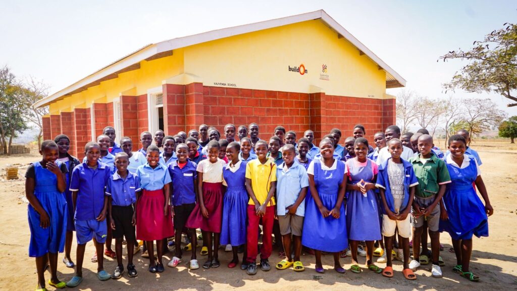 Malawian students in front of their brand new buildOn school.