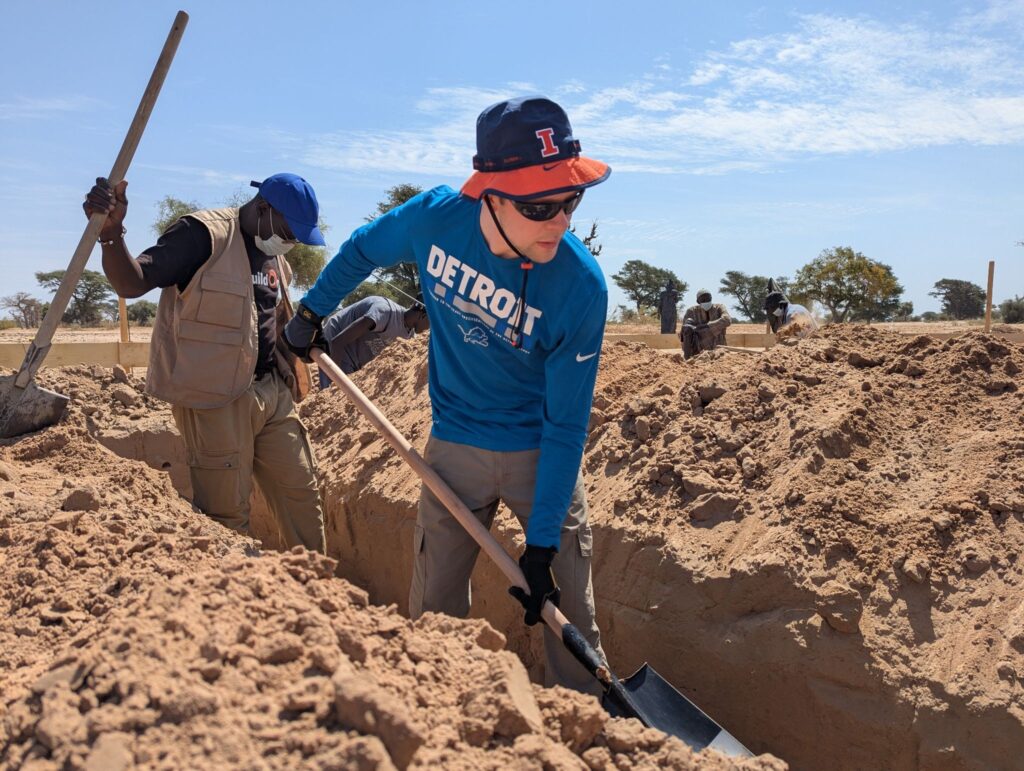 AVP of Marketing Jack Kelleher helps dig the foundation for the school.