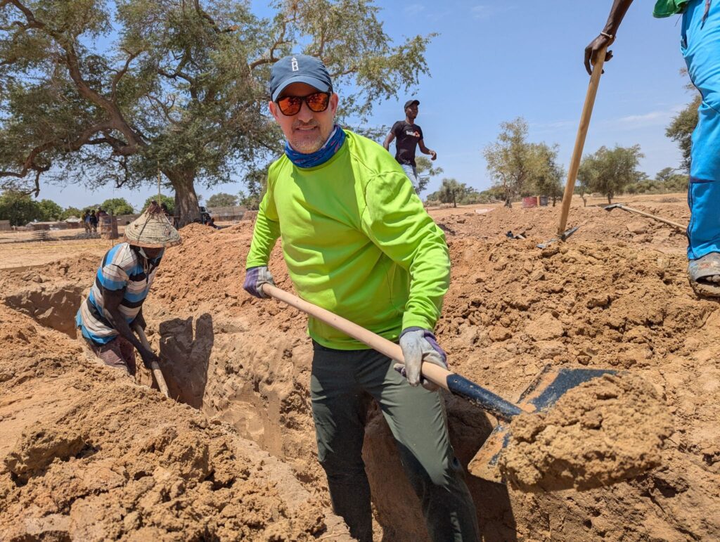 Senior Vice President & General Manager Jon Pershing helps dig the school’s foundation on the worksite.