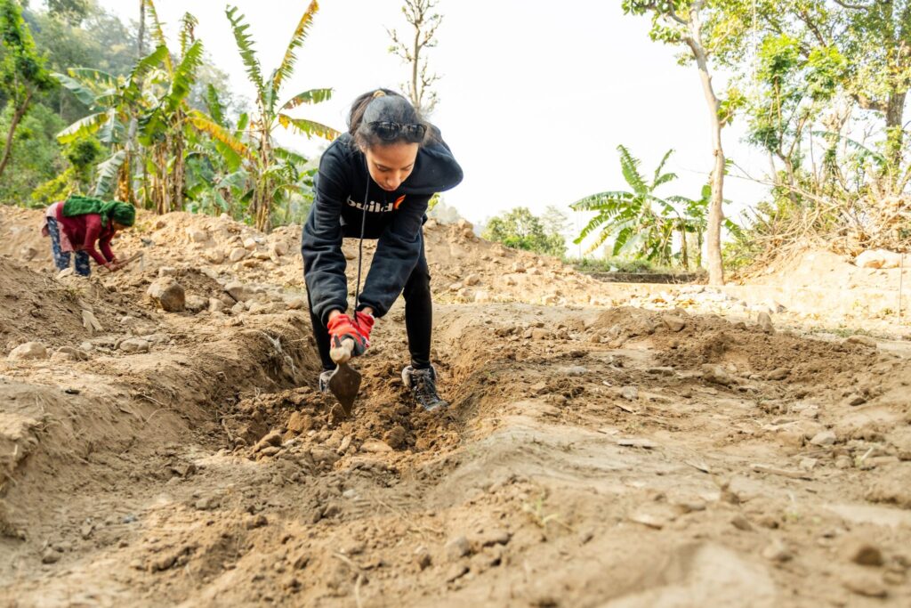 Ashley helps dig the foundation for a new school in Museti.