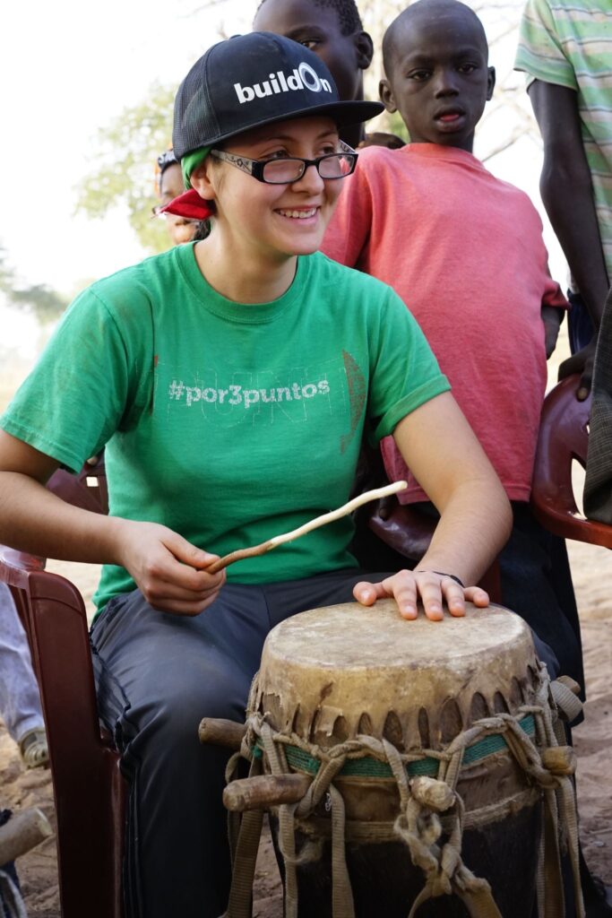 A Trek participant learns to play the drums in Senegal.