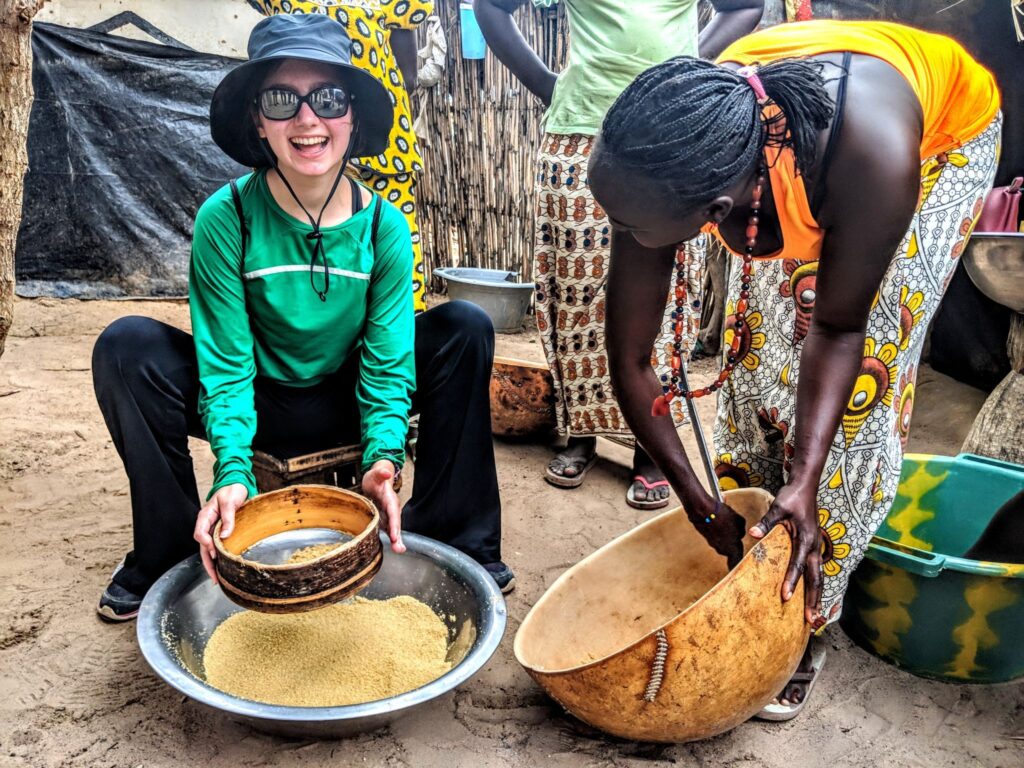A Trek participant learns how to make couscous, a staple of the Senegalese diet.
