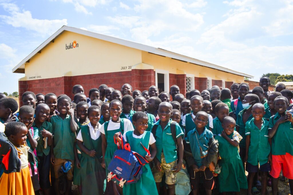 Children celebrating in front of their brand new buildOn school in Chang'ombe in 2021.