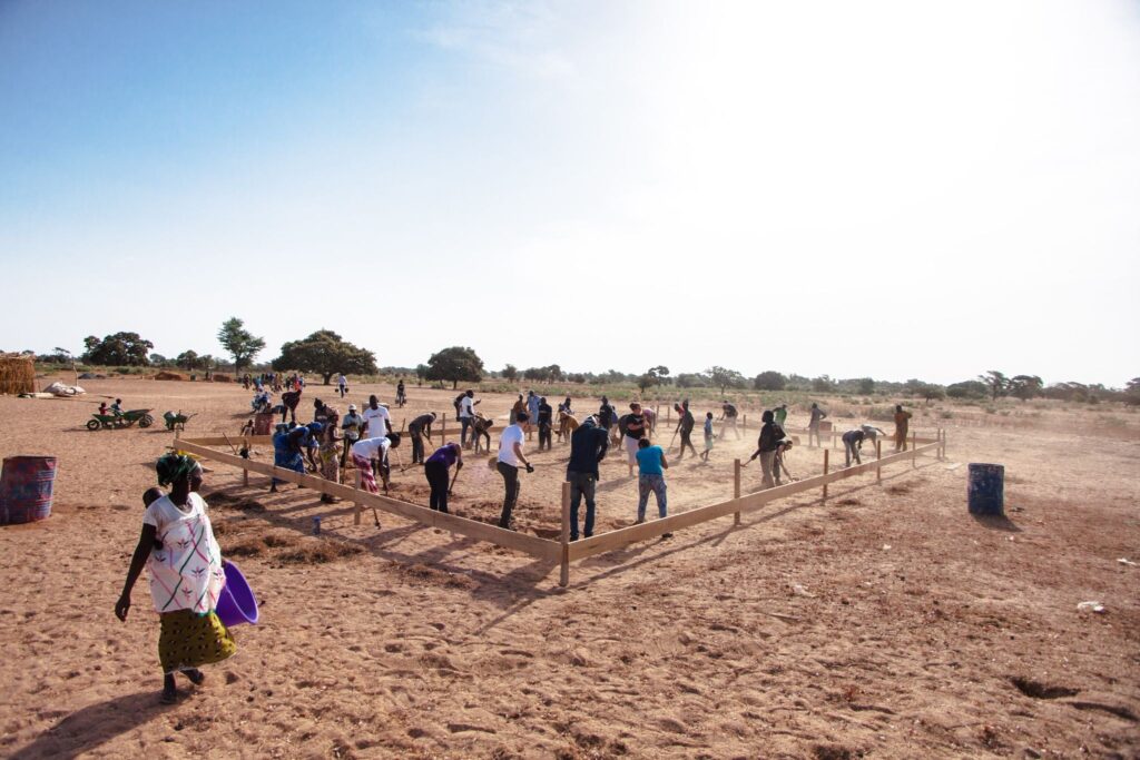 Trek participants help dig the foundation for a new school alongside community members in Senegal.