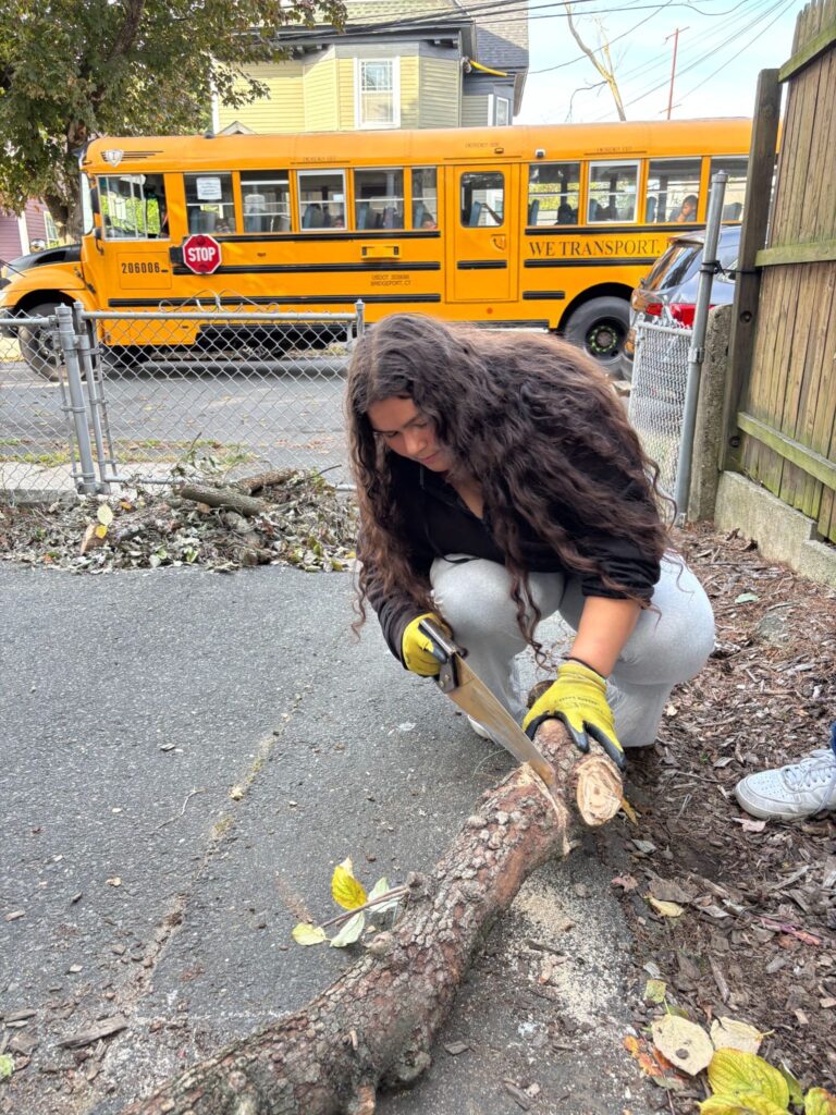 Alaina Vasquez at service at Caroline House in Bridgeport helping to clean up downed wood at the house.