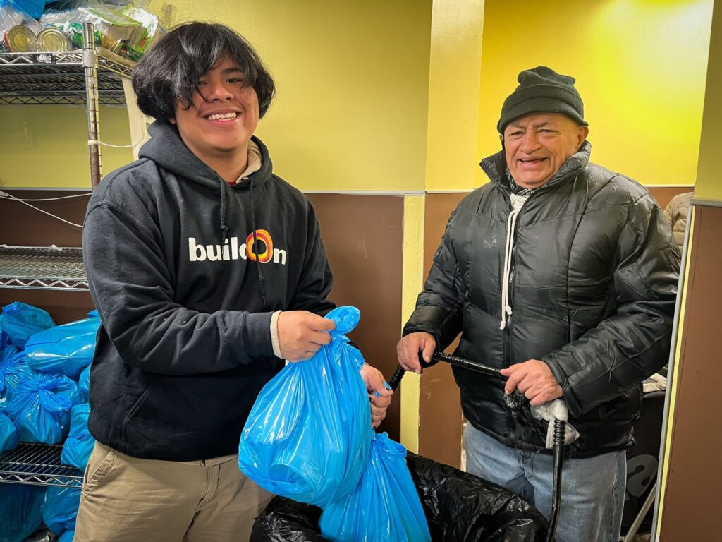 A buildOn student in the Bronx helps distribute food to his neighbors at NY Common Pantry.