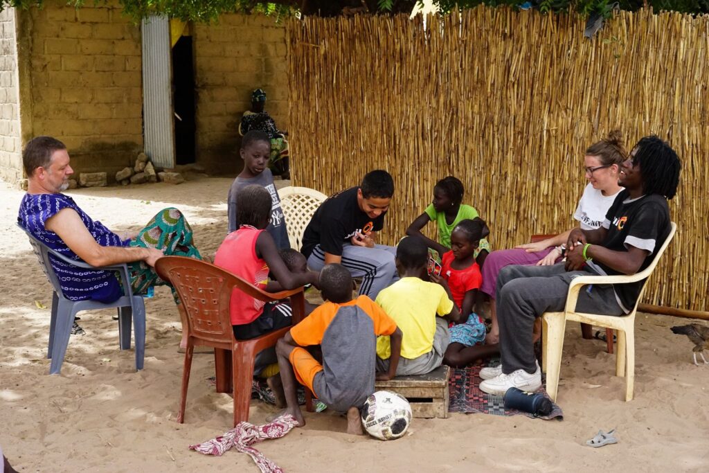 Trek participants play Uno with their host family after a day on the worksite.