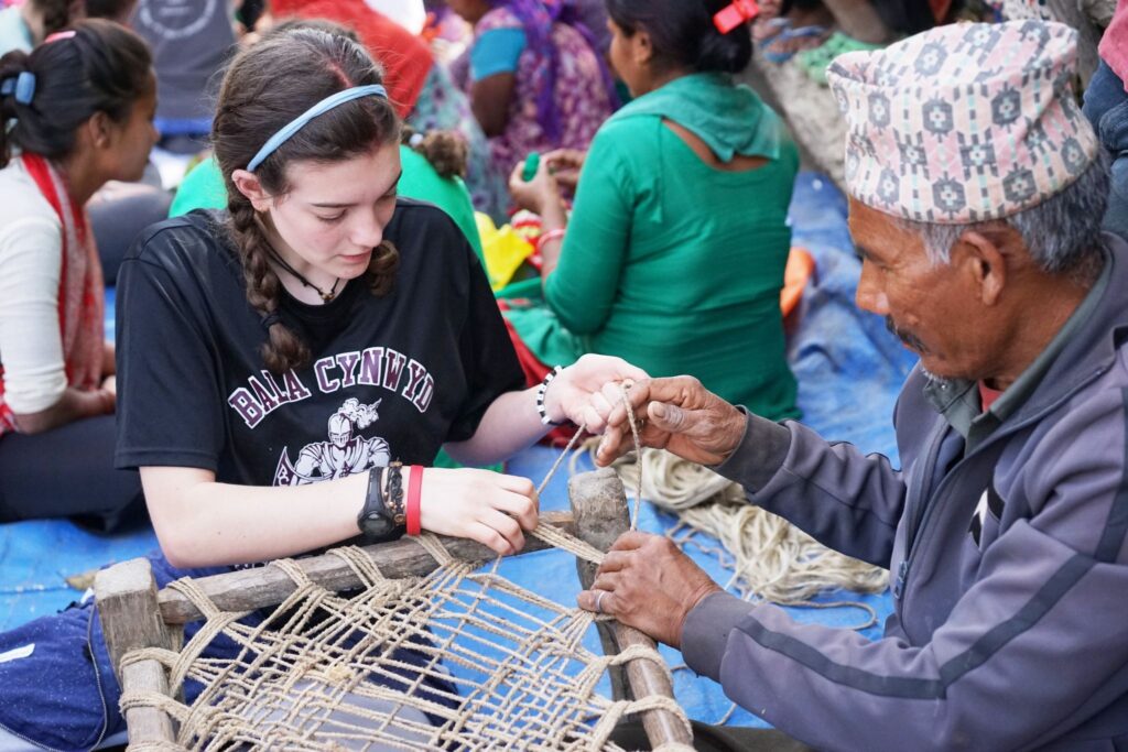 A Trek participant helps make a chair in Nepal.