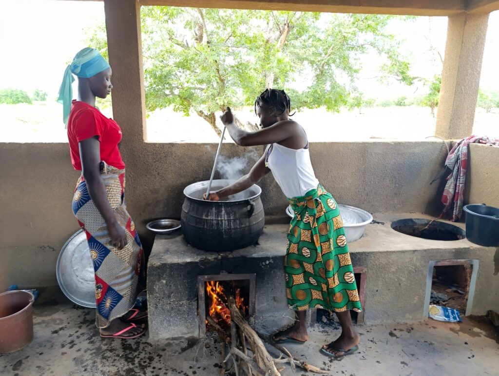 Women cook MannaPack Rice at a school canteen in Lasso.