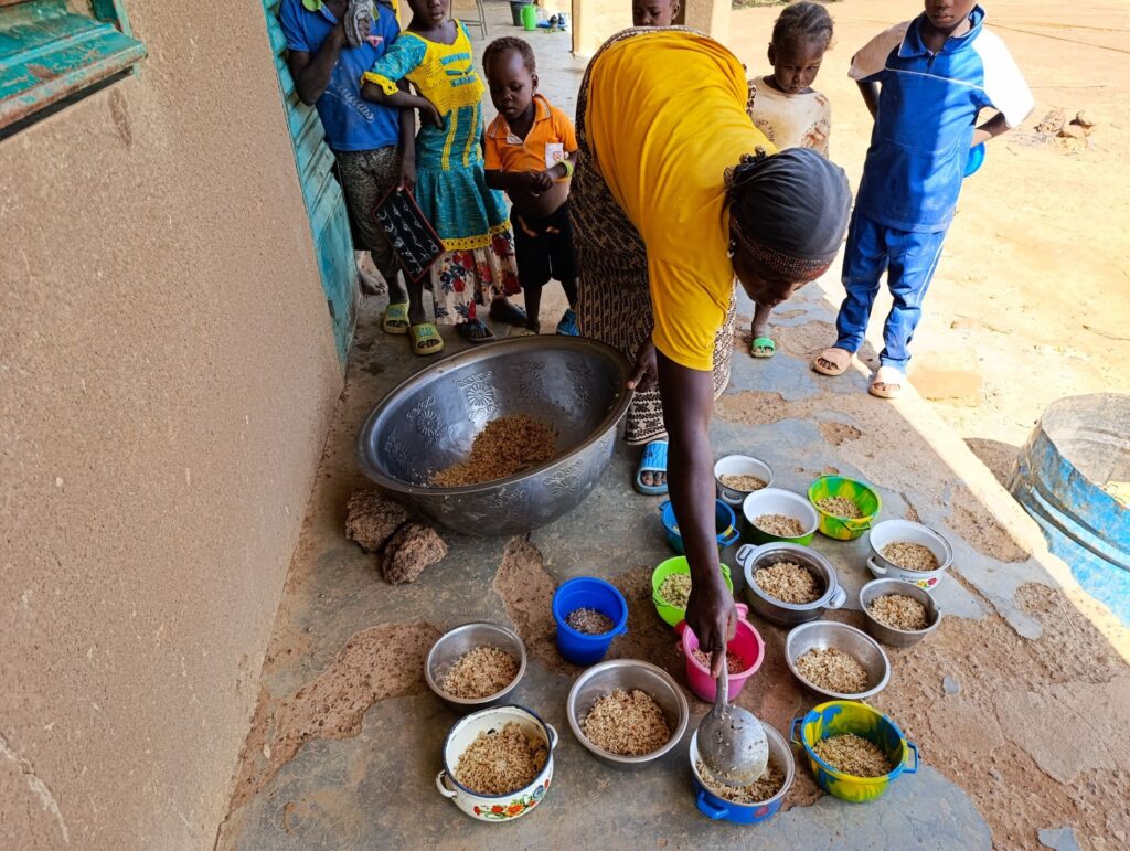 A woman in Guilla, Burkina Faso serves MannaPack Rice to Enroll students.