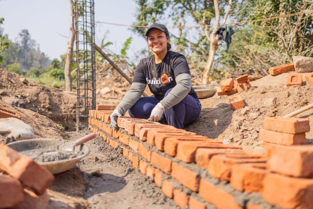 A buildOn Trek participant lays bricks for a new buildOn school in Nepal.