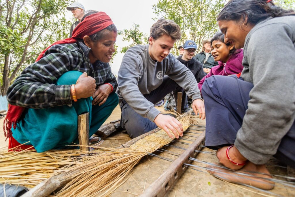 A Trek participant learns how to make baskets in Nepal.