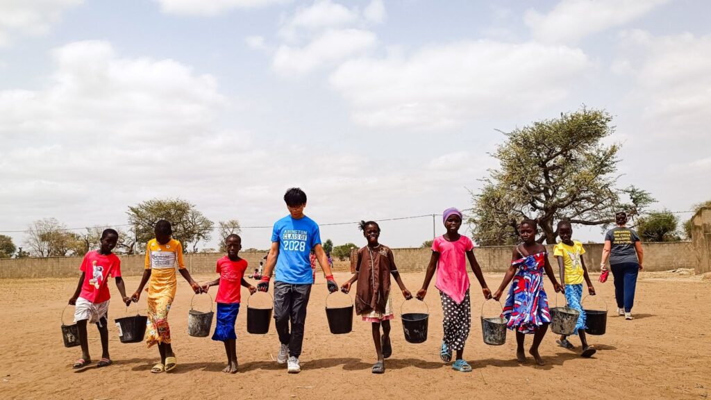 A Trek participant works with local community members in Senegal. Just like building a school, fundraising for one is a team effort!