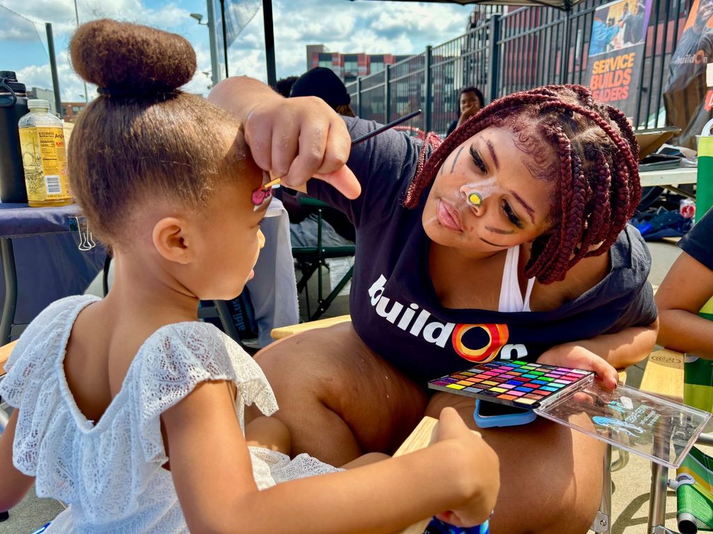 A buildOn student serves at a back-to-school event for children in Detroit.
