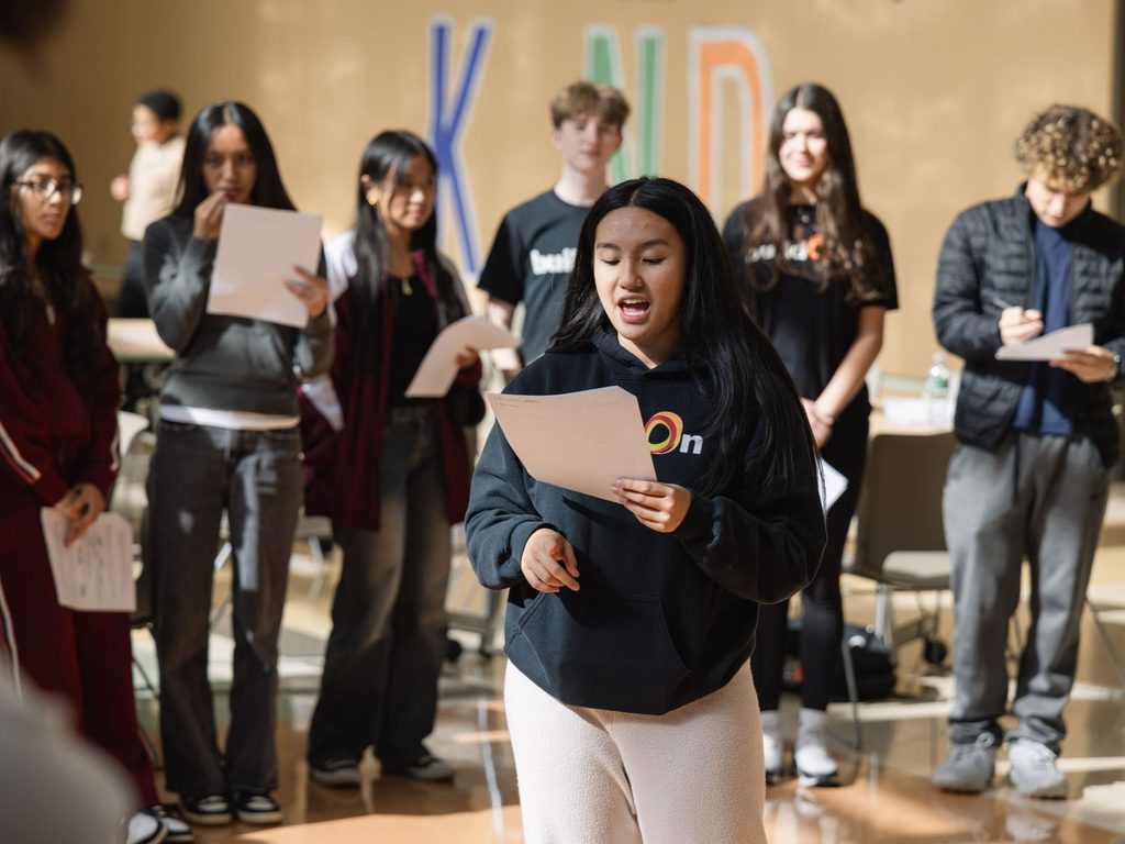 A buildOn student in Bridgeport, CT speaks at a service immersion with GenRe.