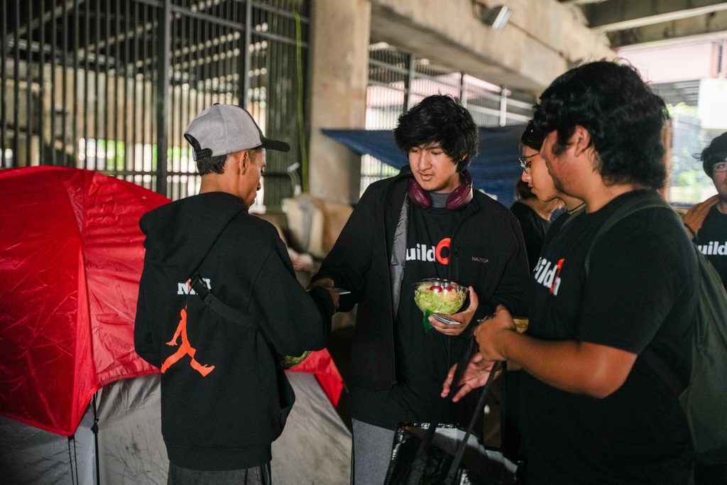 buildOn students in Chicago hand out salads to their unhoused neighbors in Pilsen.