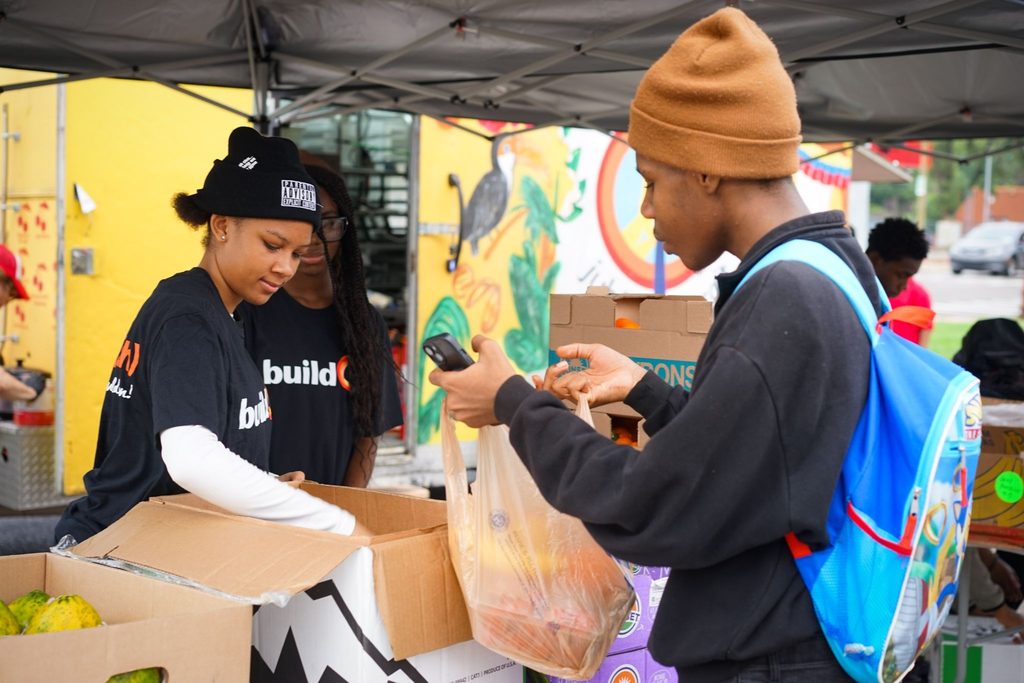 Students from Pershing High School in Detroit hand out fruit and vegetables at a weekly mobile food pantry.